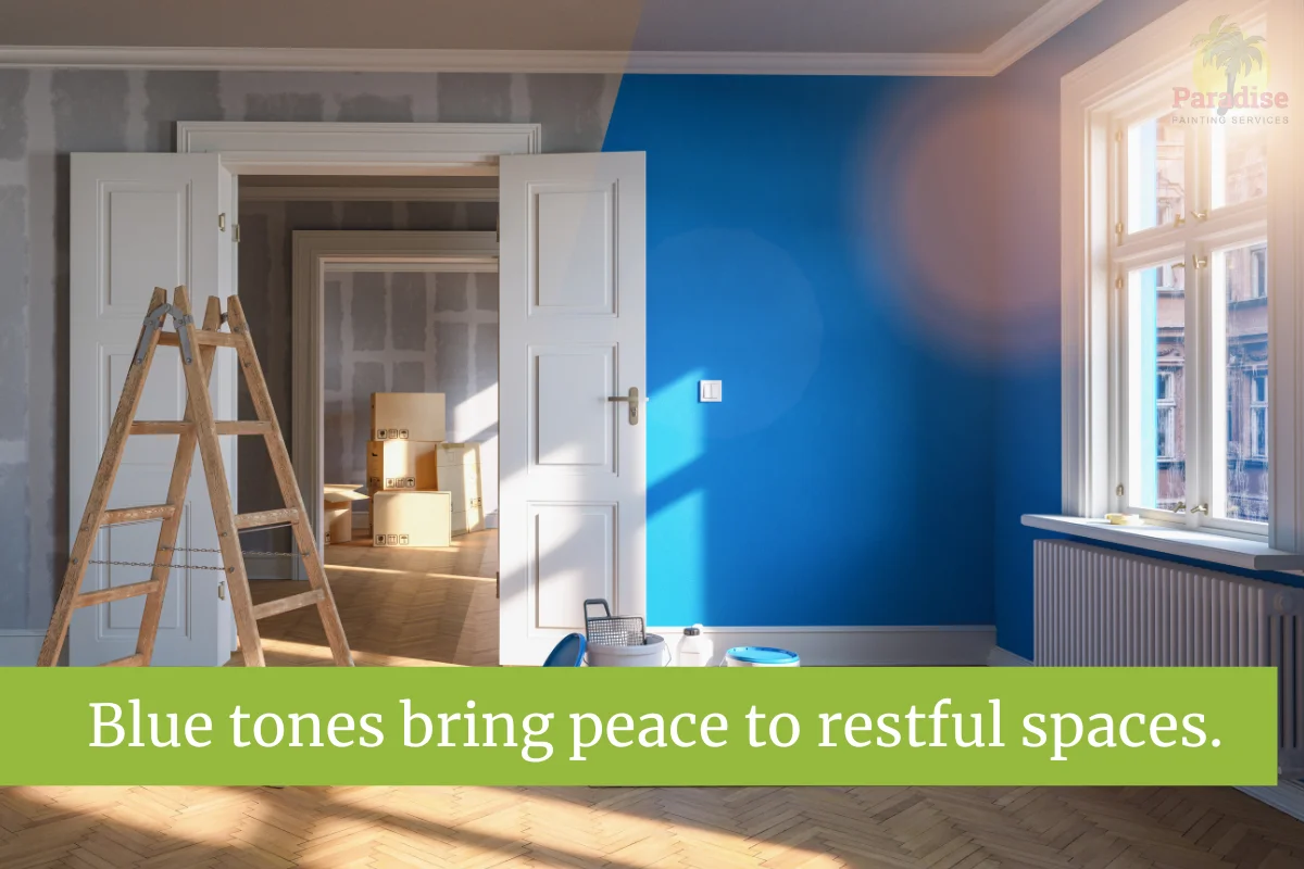 Bright blue wall in freshly painted room with ladder and painting supplies.